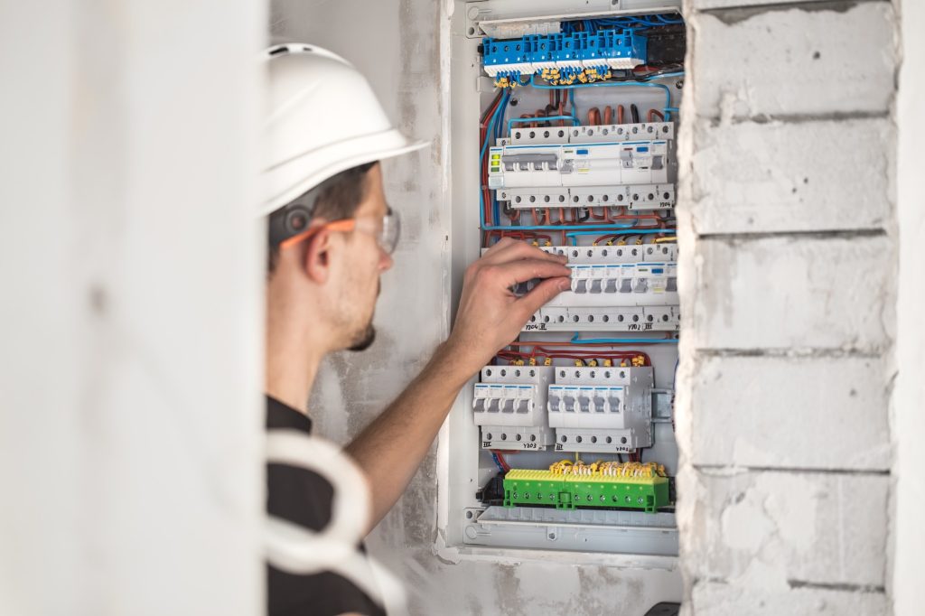 man-electrical-technician-working-switchboard-with-fuses-installation-connection-elxectrical-equipment.jpg
